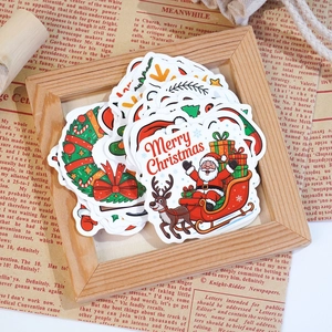 Macro shot of colorful vinyl Christmas stickers with Santa and reindeer on vintage paper