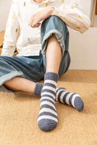 Gros plan de chaussettes en polaire corail à rayures bleues et blanches sur un mannequin