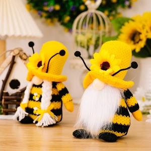 Detail von Bienen-Gnomen mit Sonnenblumenhüten und gestreiften Körpern auf Holztisch