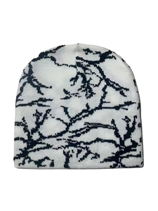 Detail showing the white knit texture and black branch-like pattern on this winter beanie