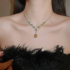 Close-up of model wearing a luxury silver necklace with yellow teardrop-shaped zircons