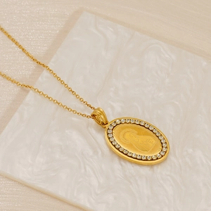Detail of gold stainless steel necklace with diamond-set oval Virgin Mary pendant