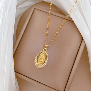 Detail of gold oval Virgin Mary pendant with sparkling white rhinestones in a jewelry box