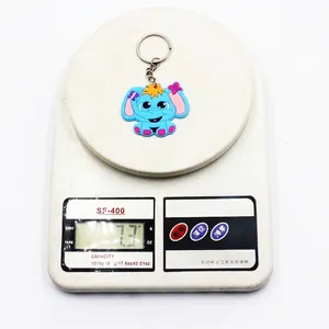 Blue cartoon elephant PVC keychain on a digital scale showing weight of 7.3g
