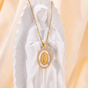 Detailed view of oval Virgin Mary pendant with gold relief on a silk fabric background