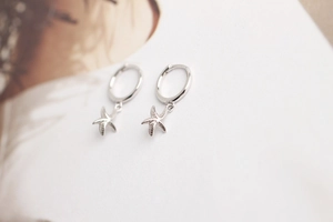 Detailed macro view of S925 sterling silver starfish hoop earrings with metallic luster