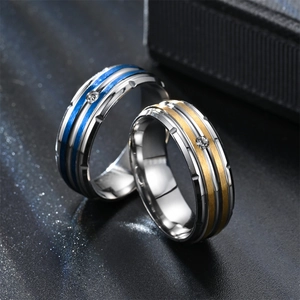 Detailed close-up of brushed titanium steel couple rings with inlaid diamonds