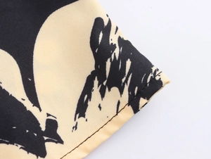 Close-up of abstract print fabric texture and precise bottom hem stitching detail