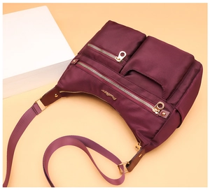 Burgundy nylon shoulder bag featuring multiple zippered compartments and a gold logo