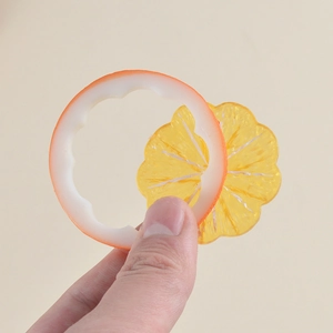 Realistic PVC lemon slice model held by fingers showing size and translucent texture