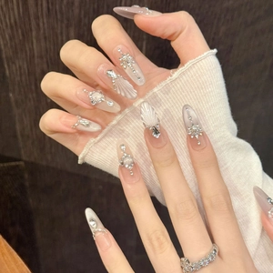 Long almond press-on nails with 3D shell texture and silver rhinestone star charms