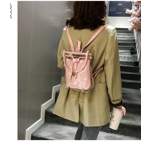 Detail view of pink transparent PVC backpack with inner pouch on a female model