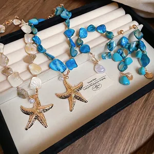 Starfish and pearl jewelry set with blue shells on a black velvet display box