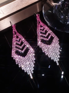 Close-up of pink gradient rhinestone tassel earrings with sparkling star effect.
