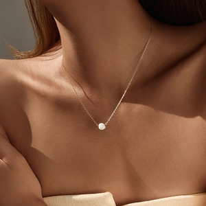 Elegant gold S925 silver necklace with round white opal pendant on model neck