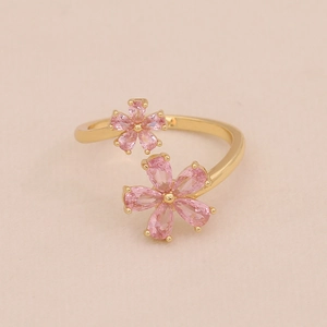 Gros plan sur une bague ajustable dorée avec cœurs en zircon rose et petit nœud