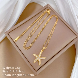 Detail view of gold starfish pendant with white zircons and S.STEEL engraving