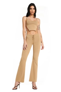 Detail of camel knit two-piece set featuring lace-up crop top and flared drawstring pants