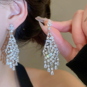 Détail de boucles d'oreilles pampilles en zircone avec gouttes d'eau et finition argentée