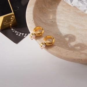 Detailed close-up of 18K gold-plated ear cuffs with round cubic zirconia on stone decor