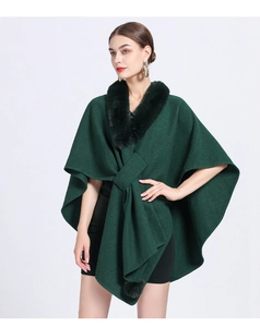 Detailed close-up of soft faux rabbit fur collar on a dark green knitted poncho cape