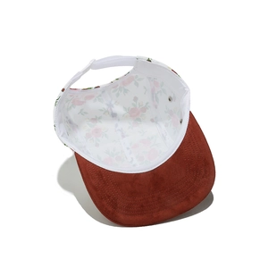 Macro shot of 5-panel hat showing floral interior print and brown suede brim texture