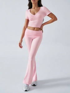 Détail d'un ensemble rose Y2K deux pièces avec haut col V et pantalon évasé ajusté