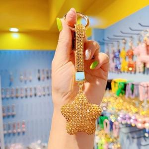 Portachiavi con stella dorata e strass scintillanti con cinturino per borsa