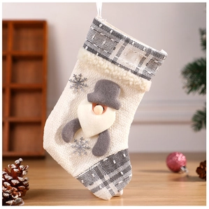 Detail of beige burlap Christmas stocking with grey plaid trim and 3D Santa applique