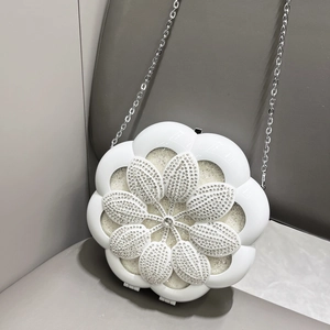 Detailed macro view of white flower evening bag with sparkling rhinestones and silver chain