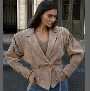 Détail de la veste en daim kaki avec épaules plissées et ceinture à nouer
