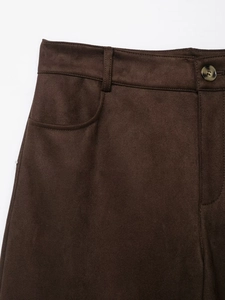 Gros plan détaillé du pantalon en daim marron foncé avec passants et bouton vintage