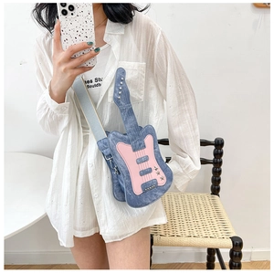Detail of guitar shaped crossbody bag in blue denim with pink accents and wide strap