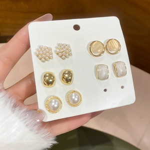Close-up of five-piece gold stud earring set with pearls and rhinestones on card