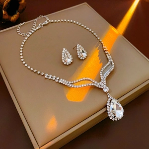 Détail du coffret collier et boucles d'oreilles en forme de goutte serti de strass