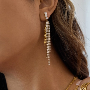 Close-up of gold stainless steel scale tassel earrings with white zircon on a model