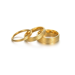 Three stackable frosted gold rings with polished edges in varying widths on white background