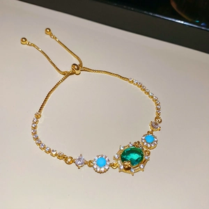 Detail of 18k gold plated adjustable bracelet with emerald zircon and turquoise beads