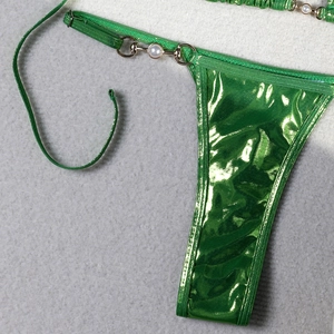 Detail of glossy green bikini bottom with metallic sheen and pearl link detail
