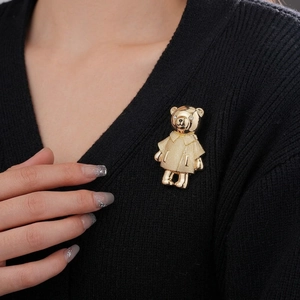 Eleganter Goldbären-Anstecknadel mit Kristallen auf einem schwarzen Strickpullover
