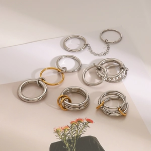 Detailed view of layered stainless steel rings with pearls and sparkling zircons
