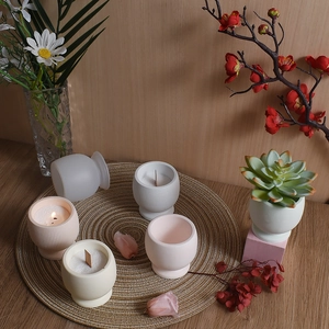 Minimalist Morandi style striped resin candle jars on a woven mat for home decoration