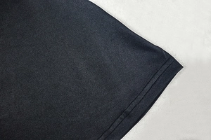 Close-up of black sleeveless dress showing high-density fabric texture and stitching