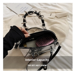 Detailed view of silver snake-pattern handbag with metal ring handle and large interior