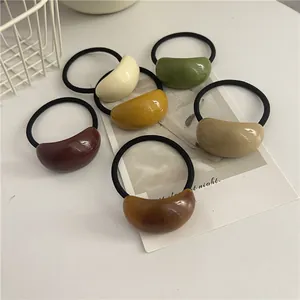 Detailed view of 6-piece earth-toned resin hair ties set on a white decorative surface