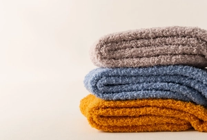 Detailed view of layered coral fleece fabric in grey blue and mustard yellow colors