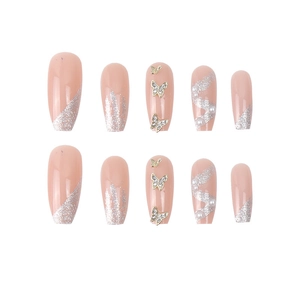 Pink press-on nails set with gold butterfly charms, pearls, and silver glitter gradient