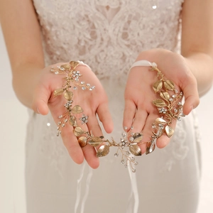 Bridal leaf headband with gold alloy flowers and rhinestones held by a bride