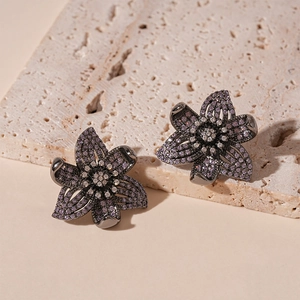 Detailed macro view of vintage flower stud earrings with purple and white zircon crystals
