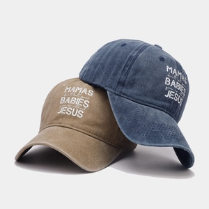 Detail of washed cotton baseball caps with printed quote on white background